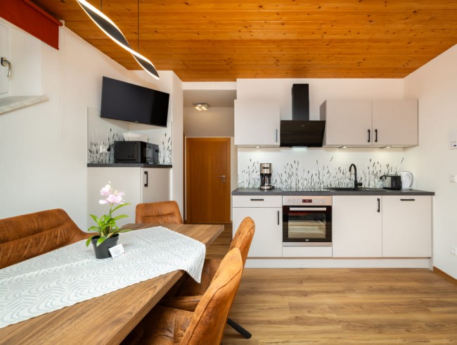Wohnk&uuml;che mit Esstisch und Flat-TV